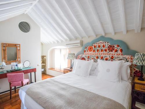 a bedroom with a large white bed with an orange headboard at La Sacristía in Tarifa