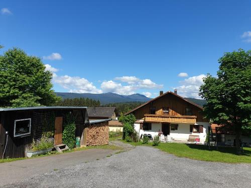 a barn and a house with a driveway at Haus Bergblick in Lindberg