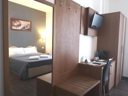 Habitación pequeña con cama y espejo. en Rome Travellers Hotel, en Roma