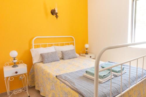 a bedroom with a bed and a yellow wall at Casa Lusco Fusco in Carrapateira