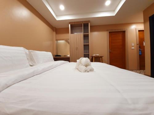 a white stuffed animal sitting on top of a bed at USABAI Riverside Boutique Hotel in Chanthaburi