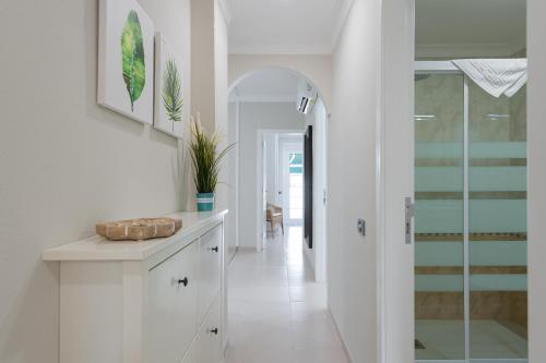 a hallway with a white kitchen with a glass door at Amarre Moon in Puerto de Mogán