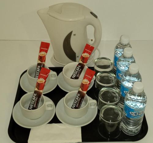 a tray with cups and bottles of water and a teapot at S.S.HOTEL SEREMBAN in Seremban
