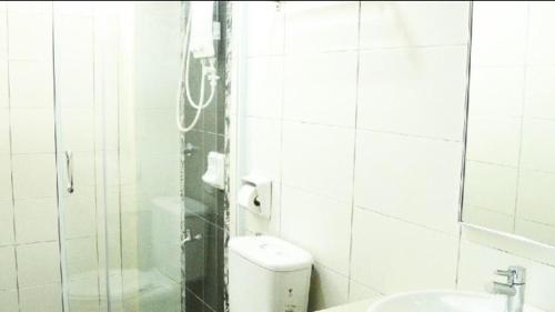 un bagno piastrellato bianco con servizi igienici e lavandino di Marina Height Seaview Resort Apartment a Lumut