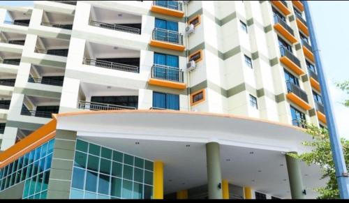 a tall white building with orange and white at Marina Height Seaview Resort Apartment in Lumut