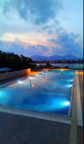 a large swimming pool with blue water at night at Marina Height Seaview Resort Apartment in Lumut