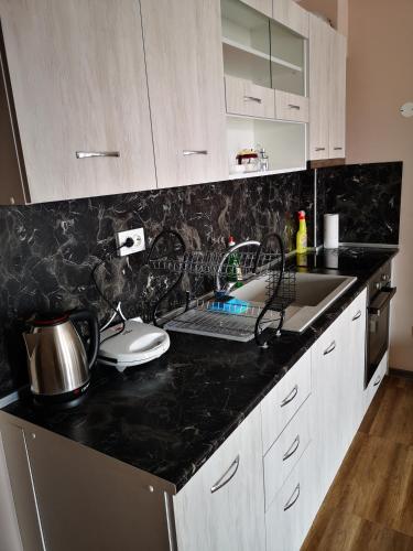 a kitchen with a black counter top and a sink at Complex Karia I in Kavarna