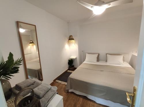 a bedroom with a bed and a mirror and a couch at Apartamento Playa in Valencia