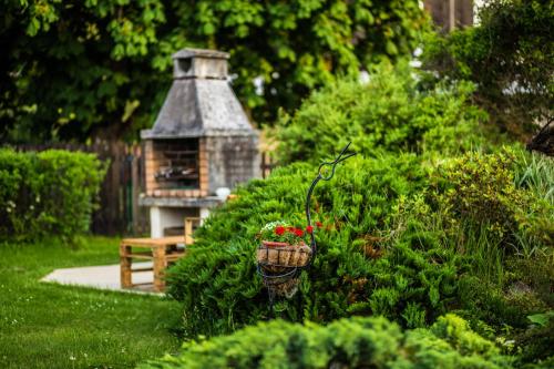 a garden with a bird house and a basket of flowers at Guest House Baltās Dūjas in Saulkrasti
