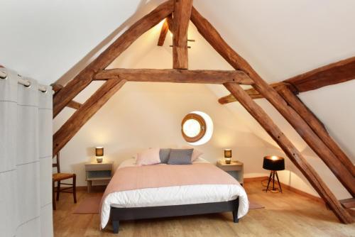 een slaapkamer met een bed op zolder bij La Pause du Perche - gîte au pied de la forêt in La Perrière