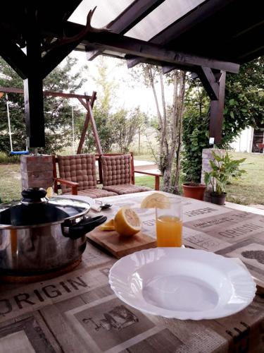 a table with a plate of food and a glass of orange juice at Panna tanya in Tahitótfalu