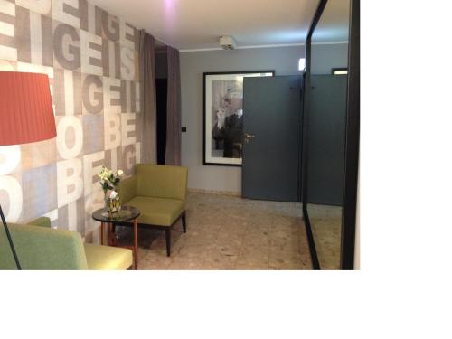 a room with a door and a chair and a table at Hotel Henry in Dreieich