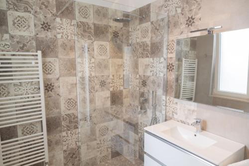 een badkamer met een wastafel en een spiegel bij Casa Anna by Home080 - Puglia Mia Apartments in Monopoli