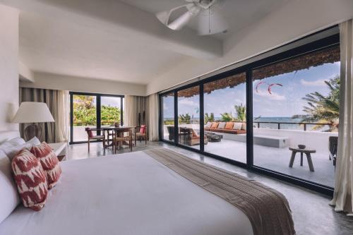 a bedroom with a large bed and a view of the ocean at Chiringuito Tulum in Tulum