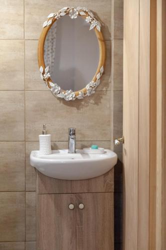 a bathroom with a sink and a mirror at Lorantina Luxury Sea View House with Starlink WiFi near Barbati & Ipsos in Spartýlas