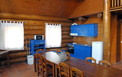 a kitchen with blue cabinets and a table and chairs at DiverLanhoso - Alojamento in Póvoa de Lanhoso