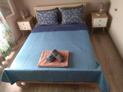 een bed met een blauw dekbed met een handdoek erop bij Villa Alexandra in Iraklitsa