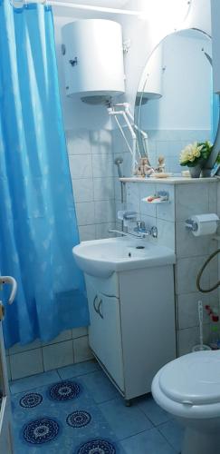 een badkamer met een wastafel, een toilet en een spiegel bij Casa Mihaela in Mangalia