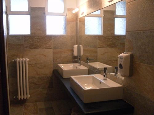 a bathroom with two sinks and a mirror at Hotel Tripoli La Margherita in Limone Piemonte