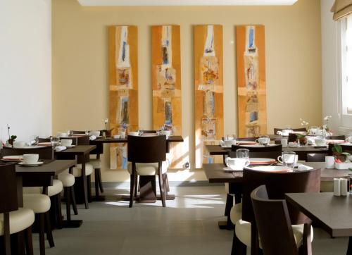 un comedor lleno de mesas y sillas en Hotel Alzinn, en Luxemburgo