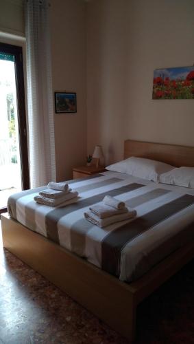 a bedroom with a large bed with towels on it at La Casa di Aurora in Reggio Calabria