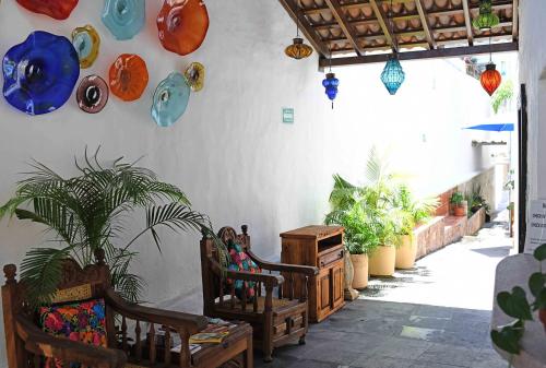 a room with chairs and plates and potted plants at Petit Hotel Pilitas in Puerto Vallarta