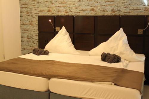 ein großes Bett mit zwei Kissen darüber in der Unterkunft Lovely Studio Cologne West - Neues Momomotel in Köln