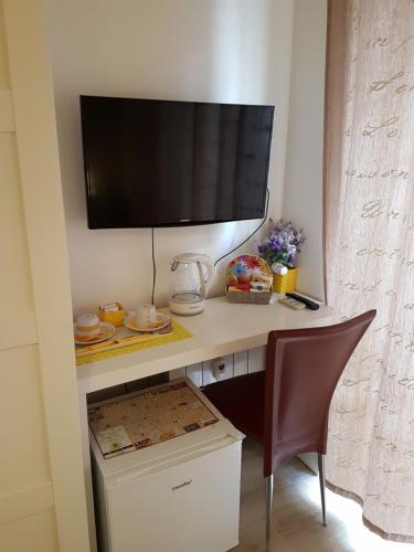 una scrivania con TV su un muro e sedia di Borgo Vaticano 84 Guest House a Roma