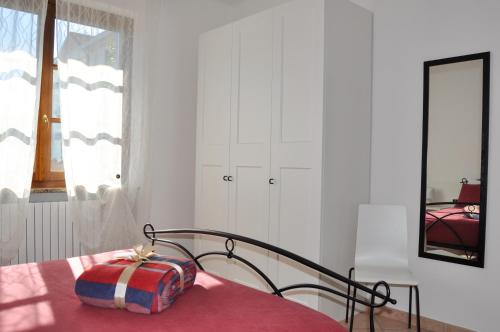 1 dormitorio con 1 cama con manta roja y espejo en B&B Sarita's Rooms, en Certosa di Pavia