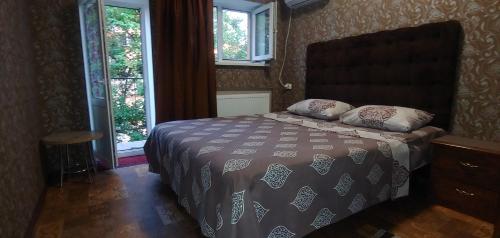 a bedroom with a bed and two windows at Апельсин in Myrhorod
