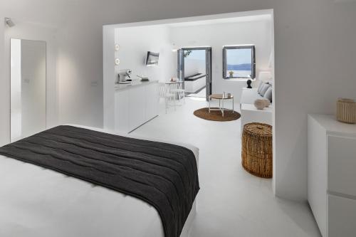 a white bedroom with a bed and a living room at Divine View Sol Homes in Fira