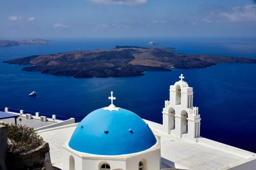 a blue and white church with a cross on top of it at Divine View Sol Homes in Fira