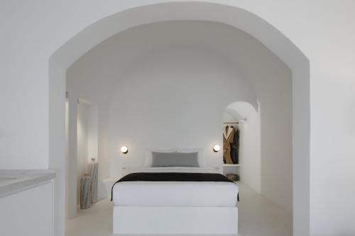 a bedroom with a white bed in a white room at Divine View Sol Homes in Fira