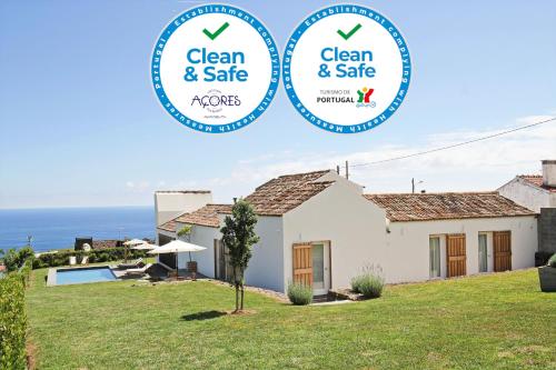 a house with two round signs that say clean and safe at Casas da Chaminé Eco Country Lodge in Nordeste