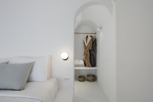 a white room with a white couch and a closet at Divine View Sol Homes in Fira