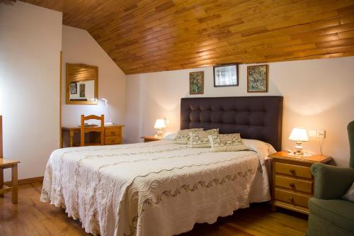 a bedroom with a large bed and a wooden ceiling at Casa rural Lucuj in Jaurrieta