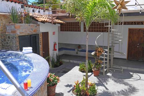 a house with a hot tub and a palm tree at Petit Hotel Pilitas in Puerto Vallarta