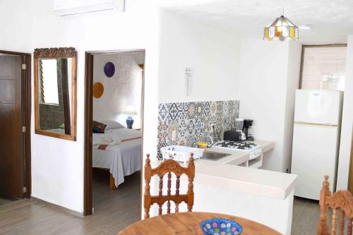 a kitchen with a white refrigerator and a room with a bed at Petit Hotel Pilitas in Puerto Vallarta
