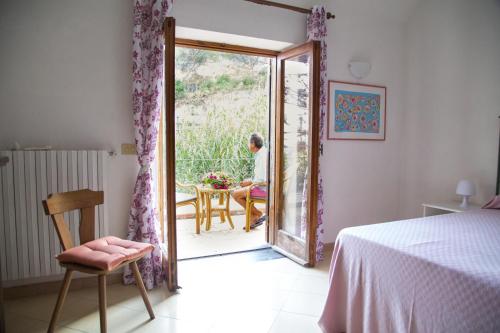 een man aan een tafel door een open deur bij Villa Paradiso in Ischia