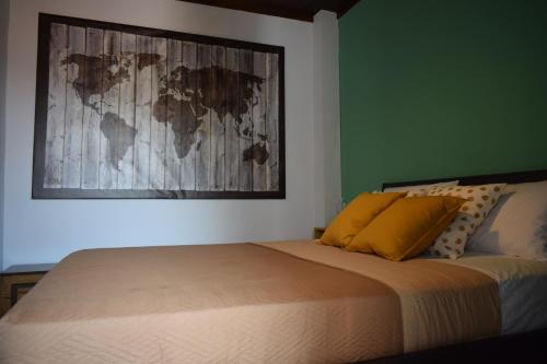 a bedroom with a bed with yellow pillows and a painting at Alisaxni Seaside Studio in Agios Ioannis Pelio