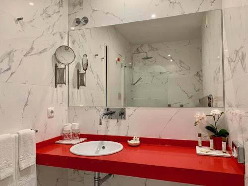 a bathroom with a red counter with a sink and a mirror at Urban Apartment Casa da Portela in Porto