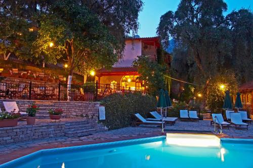 a resort with a swimming pool at night at Magda's Hotel Apartments in Parga