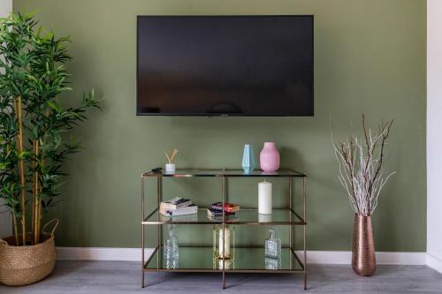 uma sala de estar com televisão numa parede verde em Blackstone Walk - Fabulous Houses with Parking em Nottingham