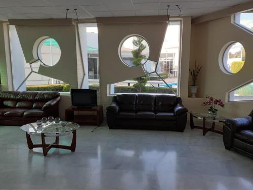 a living room with couches and tables and windows at Leo Hotel in Jerez de García Salinas