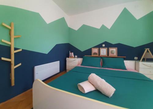 a bedroom with a bed with mountains painted on the wall at Bragorski Apartment in Makedonski Brod