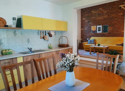 cocina y comedor con un jarrón de flores sobre una mesa en Bragorski Apartment, en Makedonski Brod