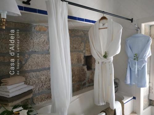a bathroom with a bath tub with a white shower curtain at Casa d'Aldeia de Souto de Lafões OLIVEIRA DE FRADES in Oliveira de Frades