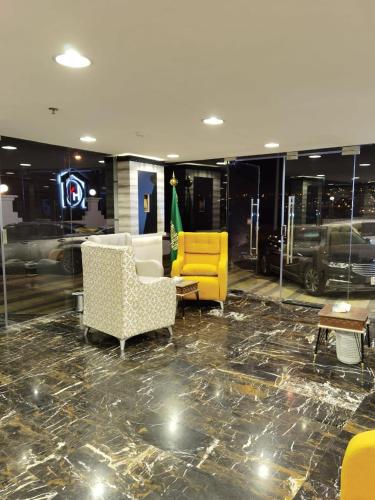 a lobby with a yellow chair and a couch at فندق الحاتمية in Abha