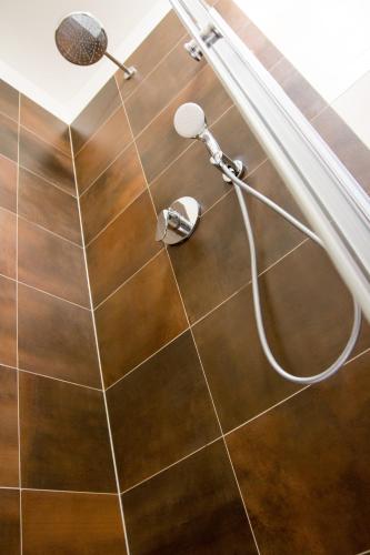 a shower in a bathroom with a hose on the floor at Apartmány ADH Dolní Morava in Dolní Morava