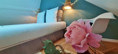 uma flor rosa num vaso ao lado de um quarto em -La Maison Balancoire - Parking privé offert - Coeur historique -La Clef de Honfleur em Honfleur
